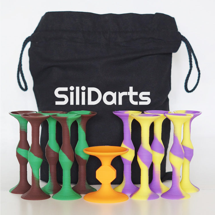 Im Hintergrund steht ein schwarzer Beutel mit der Aufschrift “SiliDarts”. Davor aufgereiht das Wurfspiel SiliDarts.