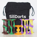 Im Hintergrund steht ein schwarzer Beutel mit der Aufschrift “SiliDarts”. Davor aufgereiht das Wurfspiel SiliDarts.
